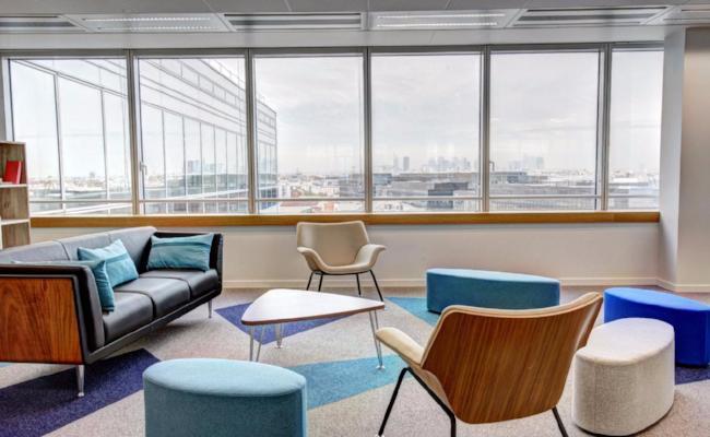 Bright minimal home office with large window, wooden desk, indoor plant and CP Slippers on the floor — workspace designed for creativity and comfort